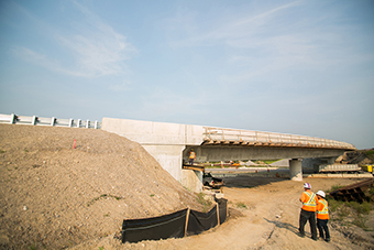 Photo of a bridge under construction with workers on site