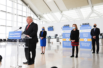 Photo du premier ministre Doug Ford, de la vice-première ministre et ministre de la Santé, Christine Elliot, et de la solliciteure générale, Sylvia Jones, lors de l’annonce du test de dépistage de la COVID-19 à l’aéroport international Pearson de Toronto