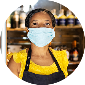 Image of hospitality worker wearing apron and mask.
