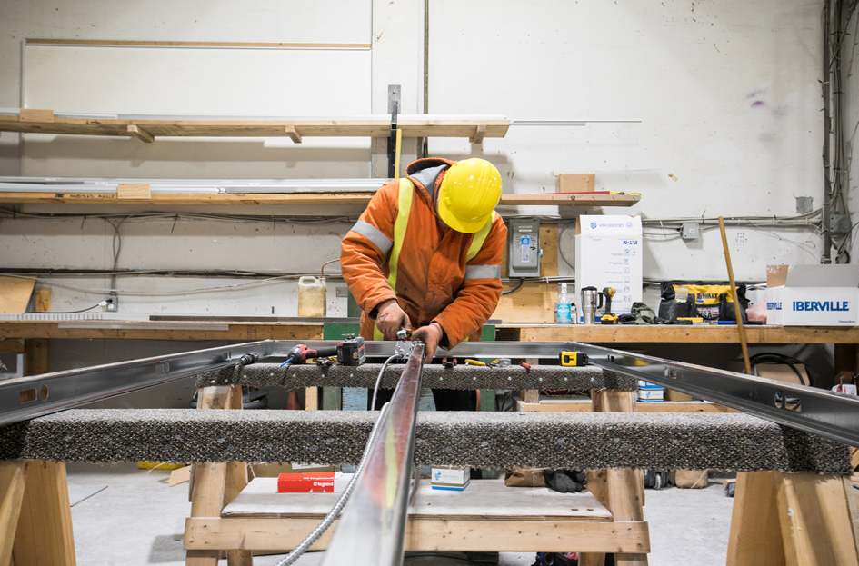 Photo d’un travailleur de la construction qui assemble des matériaux servant à la construction de logement dans un entrepôt à Niagara