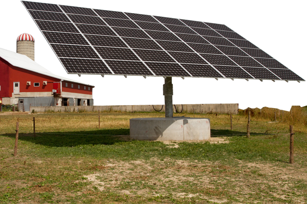 Photo of a solar panel with a red barn in the background.