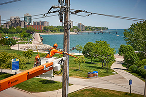 Hydro worker in a lift, fixing electrical wires