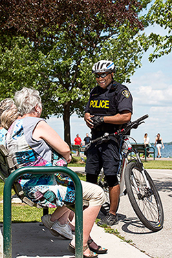 Police officer talking to two elderly women on a bench