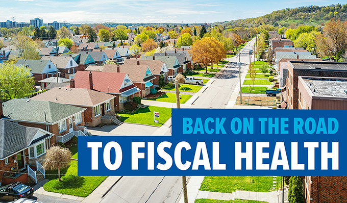 Photo of vibrant neighbourhood with text: Back on the road to fiscal health