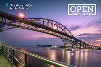 Photo of bridge with text: Blue Water Bridge, Sarnia, Ontario - Open for business