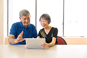 Deux personnes âgées qui utilisent une tablette