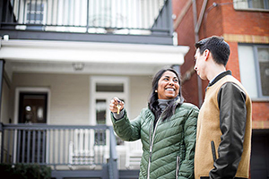 Un couple devant leur nouvelle maison, les clefs à la main