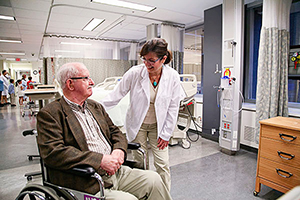 Un patient âgé en fauteuil roulant et une médecin dans un hôpital