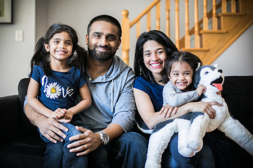 Famille de quatre personnes assise sur un canapé