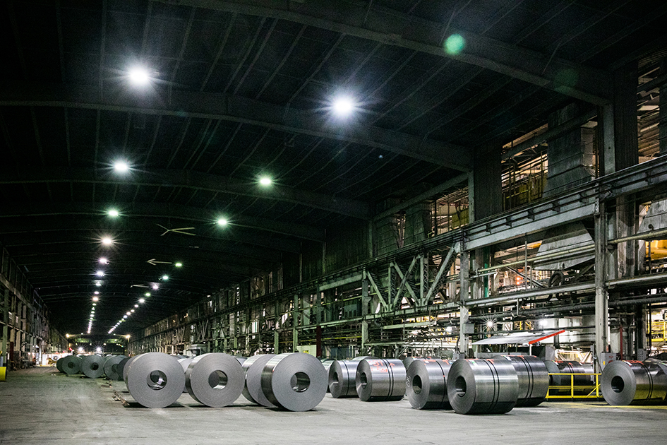 Photo of large rolls of steel sheets and machinery inside a steel mill in Hamilton