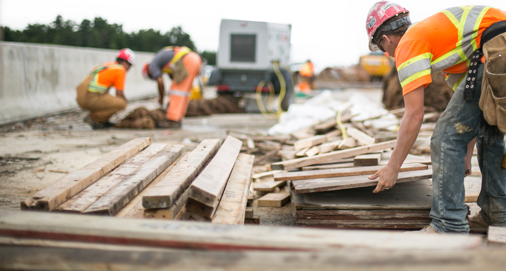 Photo de trois travailleurs de la construction sur un chantier d'autoroute.