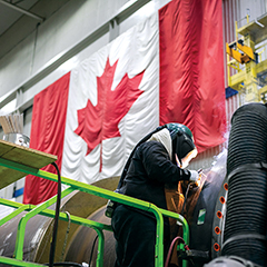 Photo d’un travailleur soudant de l’équipement industriel dans des installations de fabrication.