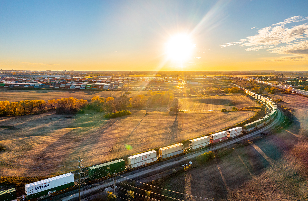Photo des installations de la gare de triage de Vaughan montrant des trains de marchandises traversant le site, au lever du jour.